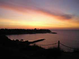 Beautiful sunrise over Cabo Roig marina and watchtower.